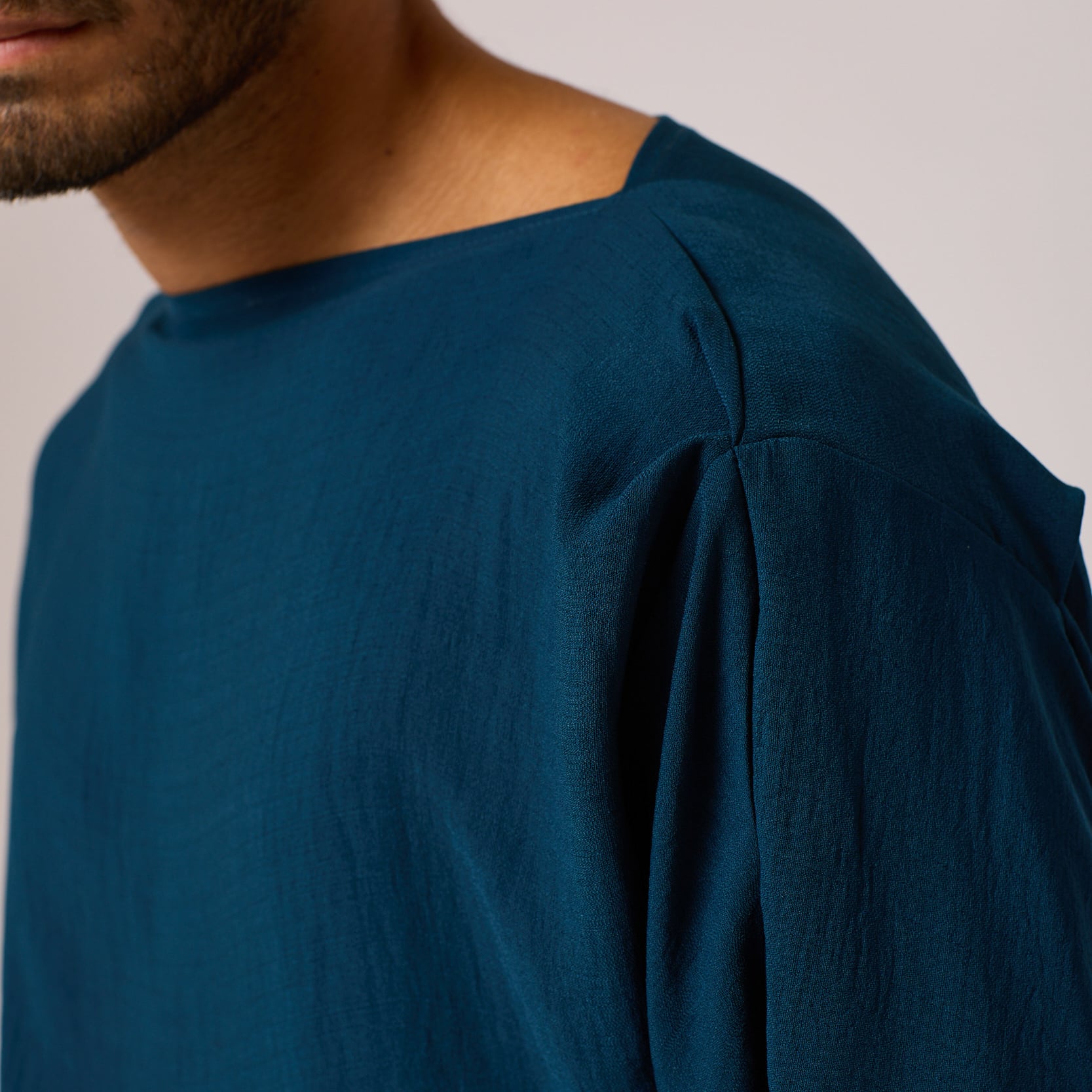 ZERØ London - Close up, mens zero waste long sleeve high/low shirt with bateau neck in teal blue, designed & made in London